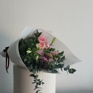 Soft pastel seasonal flowers wrapped in white Kraft paper with burgundy ribbon. Designed by Bendigo florist Blumetown.