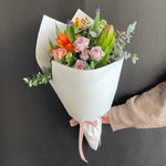 Load image into Gallery viewer, Flower bouquet with bright coloured orange, purple and pink flowers wrapped in white Kraft paper with pink bow. Bouquet designed by Bendigo Florist Blumetown. 
