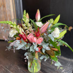 Load image into Gallery viewer, Bold bright flowers in lilies, roses and seasonal flowers in a glass vase. 
